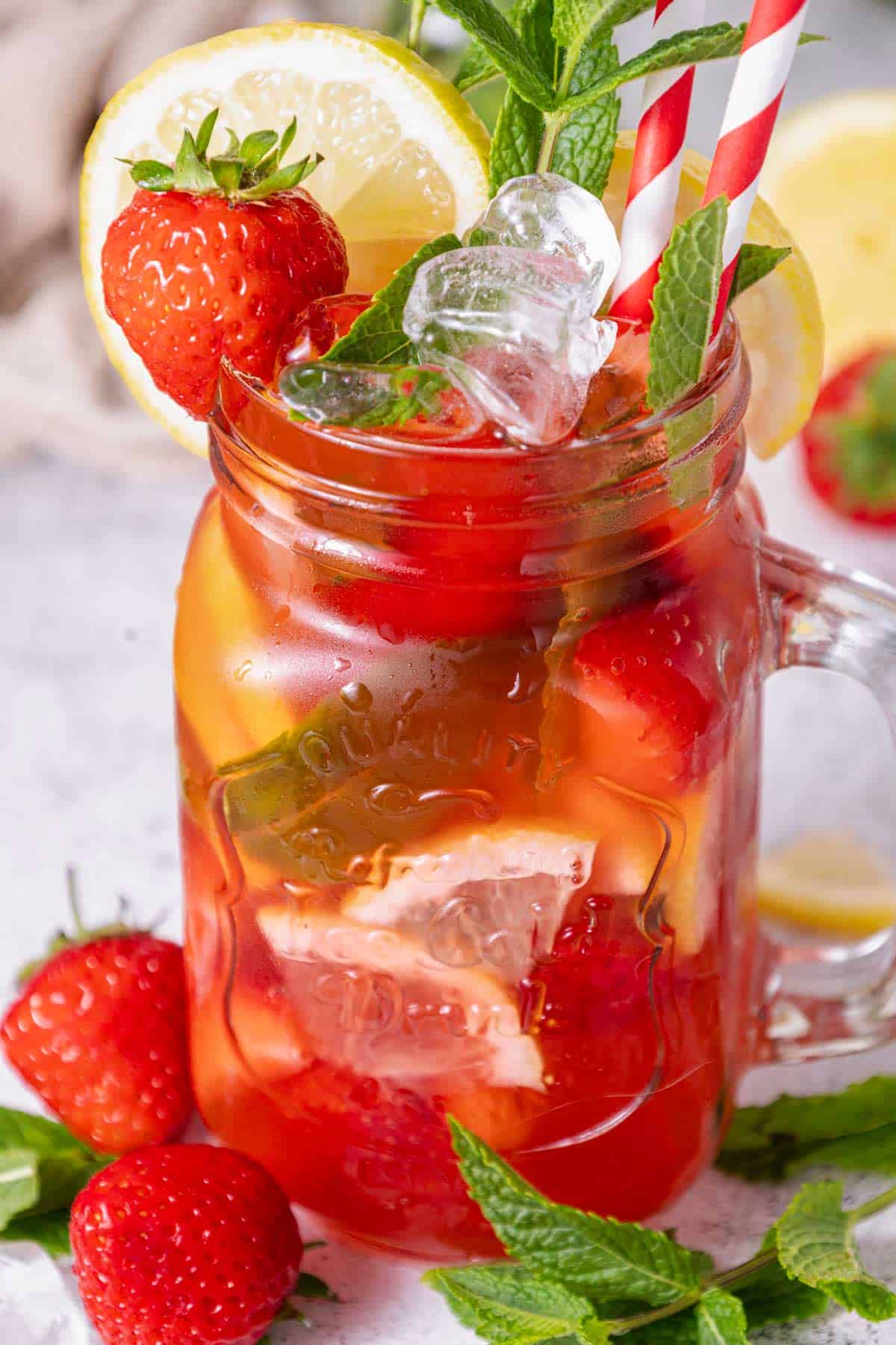 a jar of virgin mojito with strawberries and lemon.