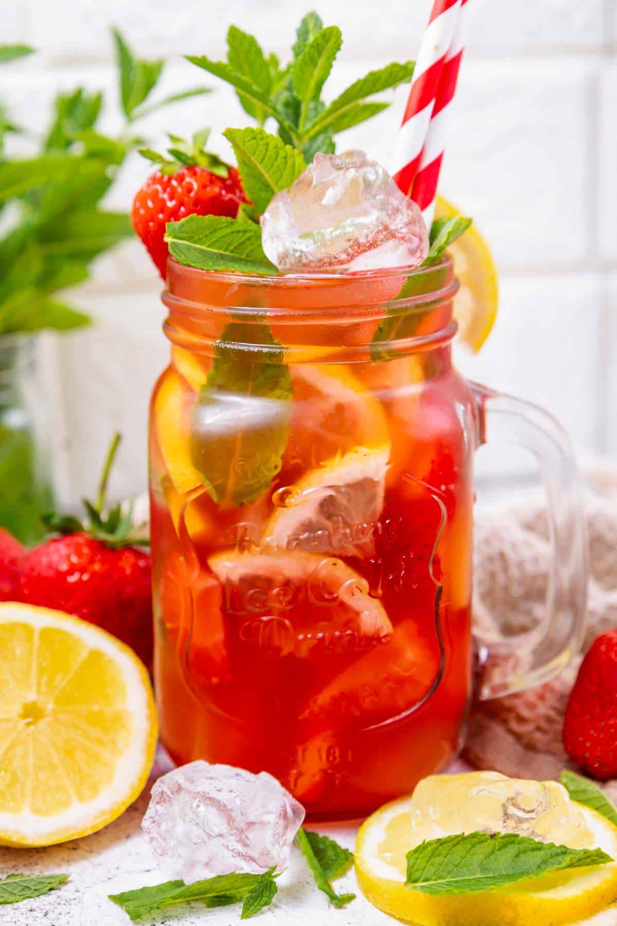 a jar of virgin mojito with strawberries and lemon.