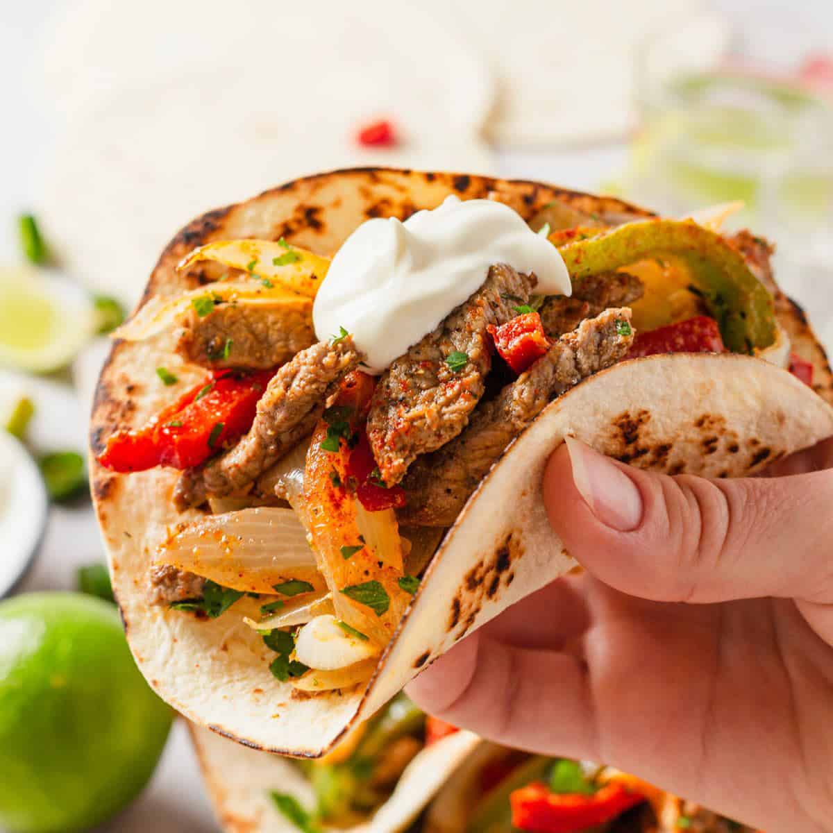 steak fajita tacos with sour cream.