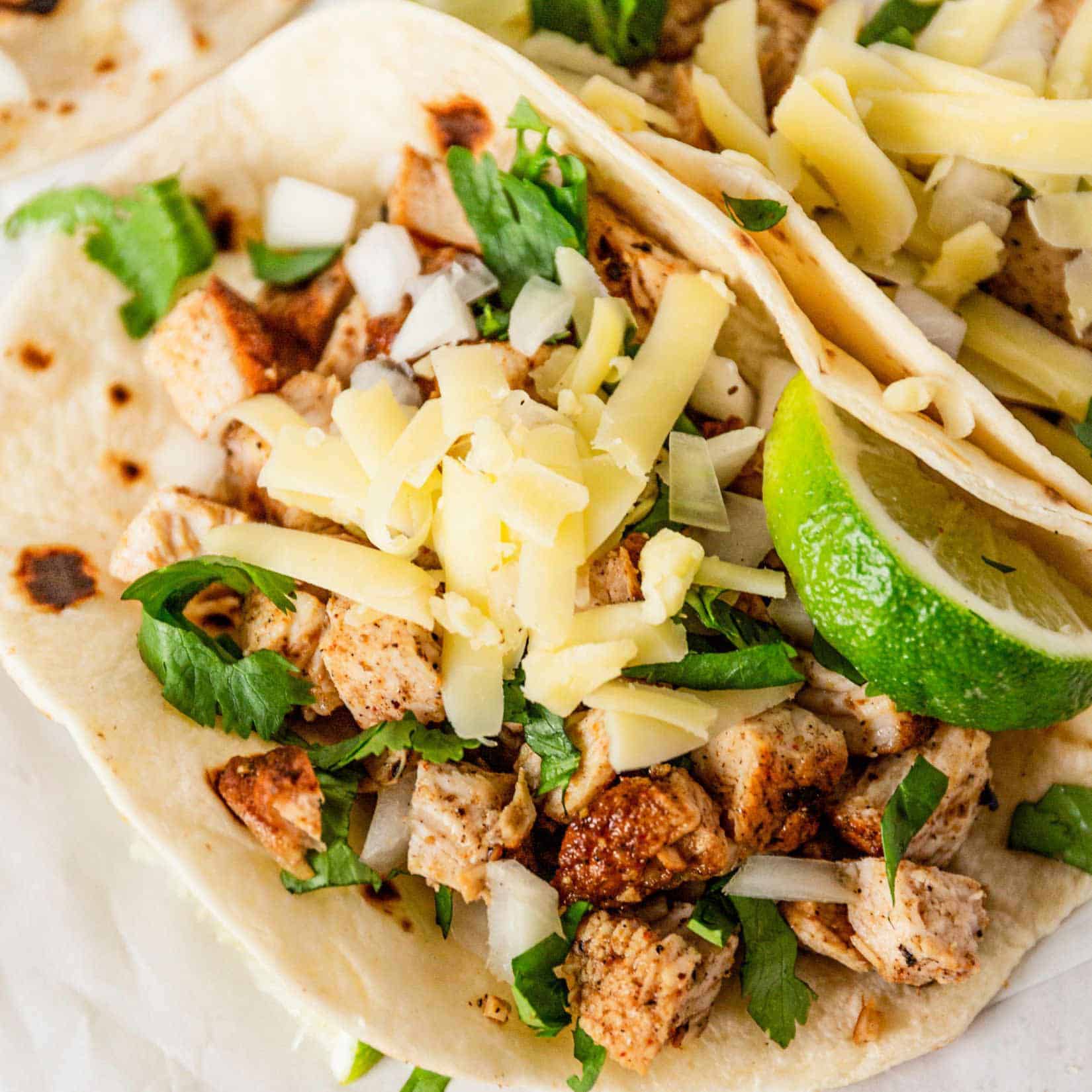 simple chicken street tacos with cheese and seasoning.