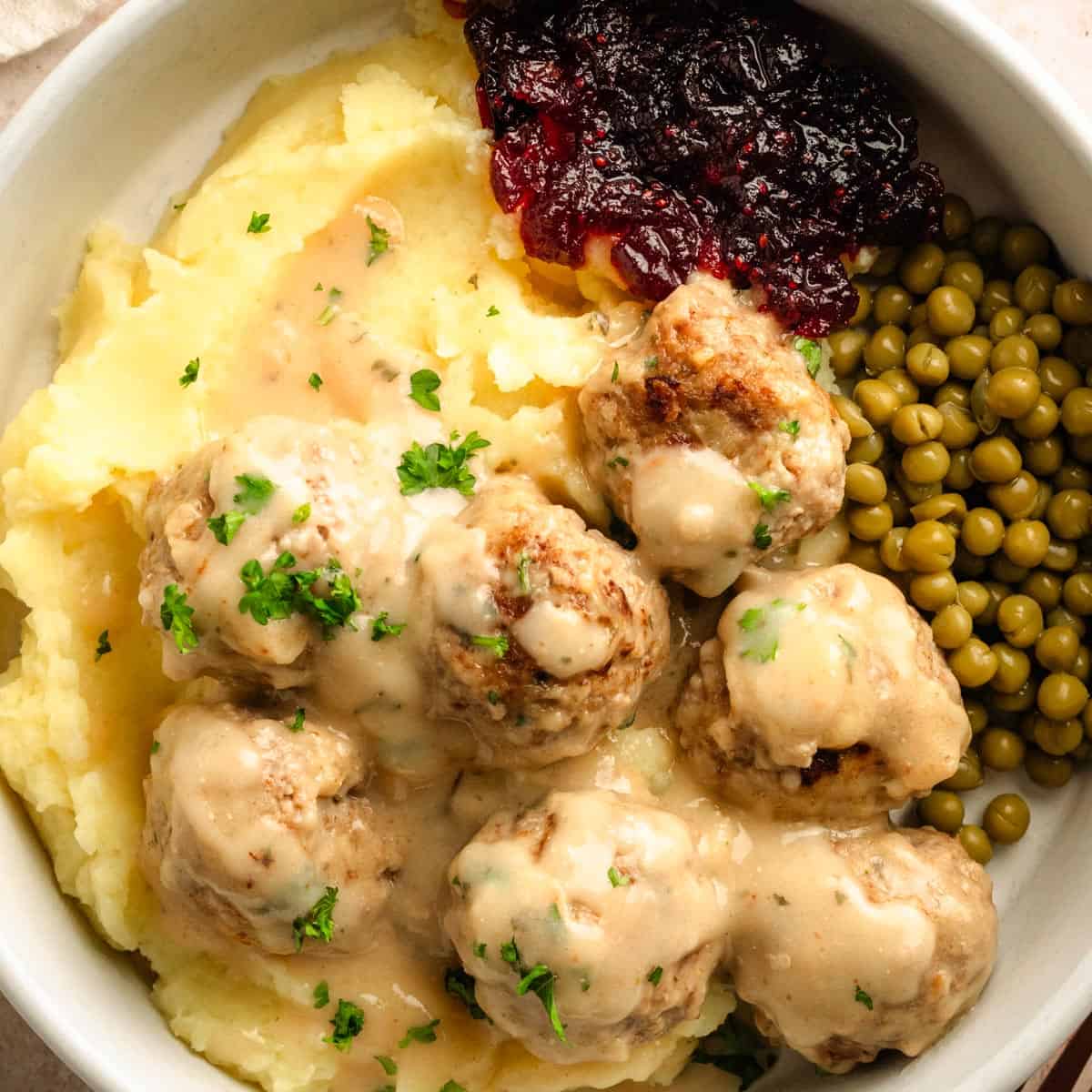 Swedish Meatballs in creamy gravy with peas, cranberry jam and mashed potatoes.