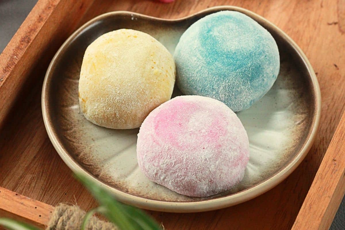 Three colorful mochi ice cream balls on a small plate