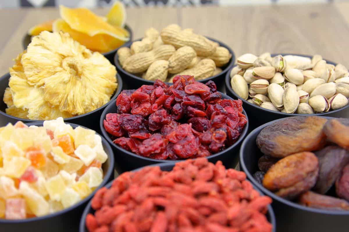 Bowls of dried fruits, nuts, and seeds arranged on a table