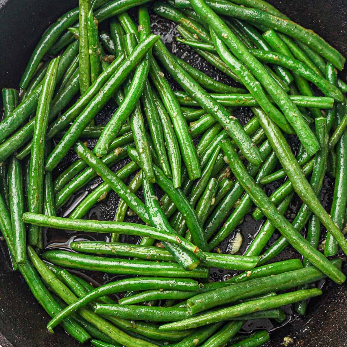 Green beans cooking in a pan, turning bright green.