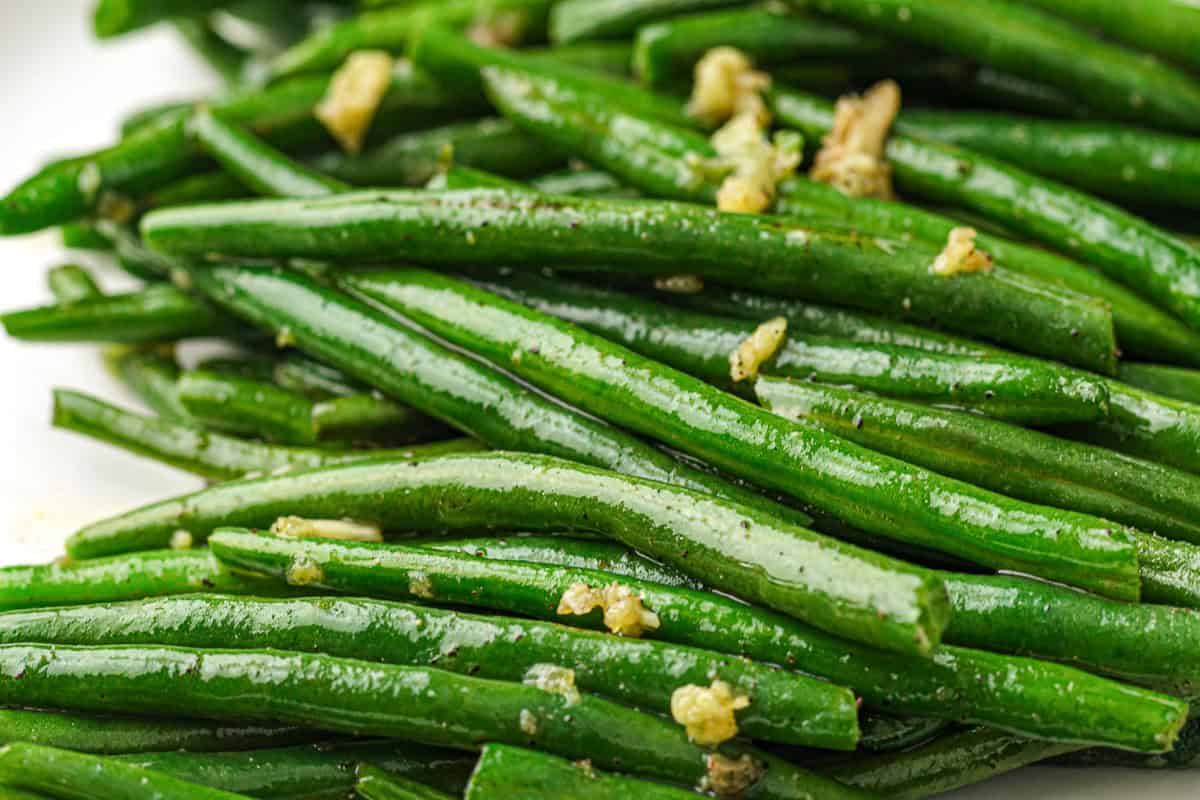 Close-up of fresh trimmed green beans glistening before cooking.