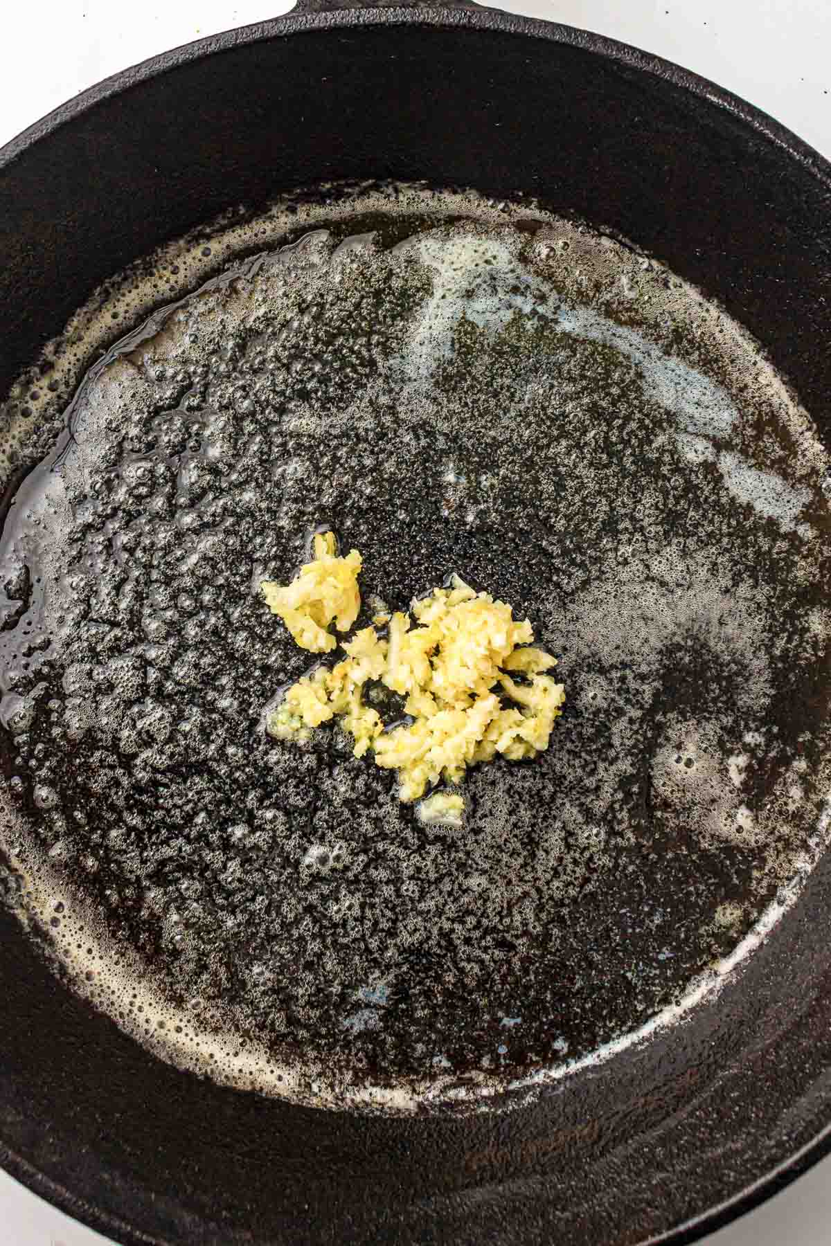 Butter melting in a skillet over medium heat.