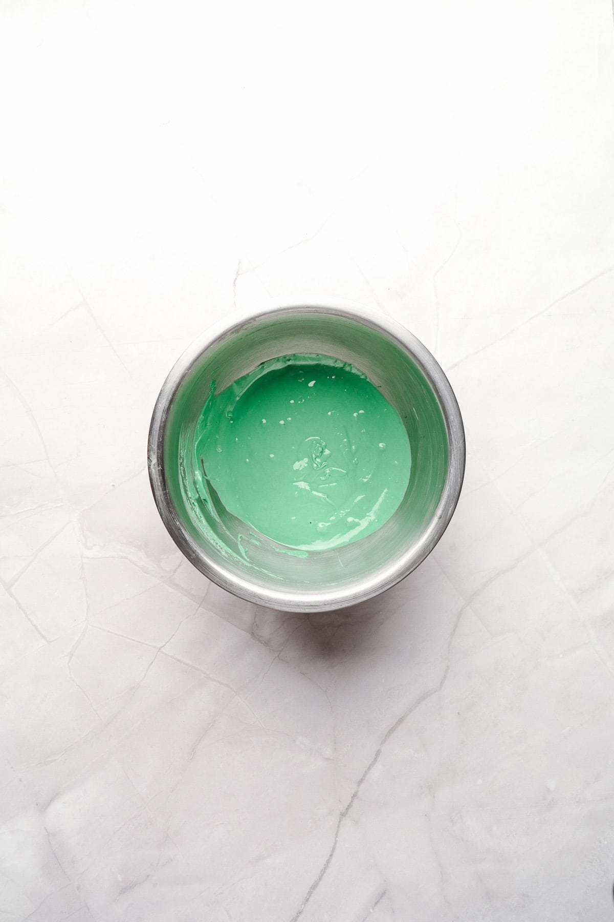 Melted green candy coating in a mixing bowl.