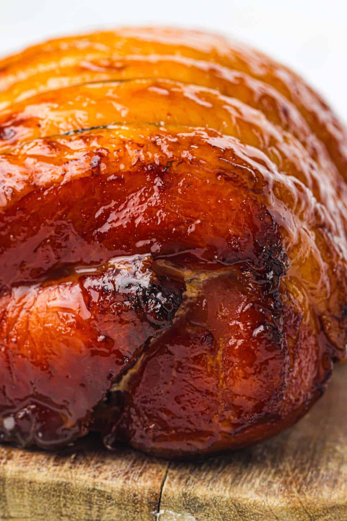 Close-up of glossy honey glazed ham with browned edges.