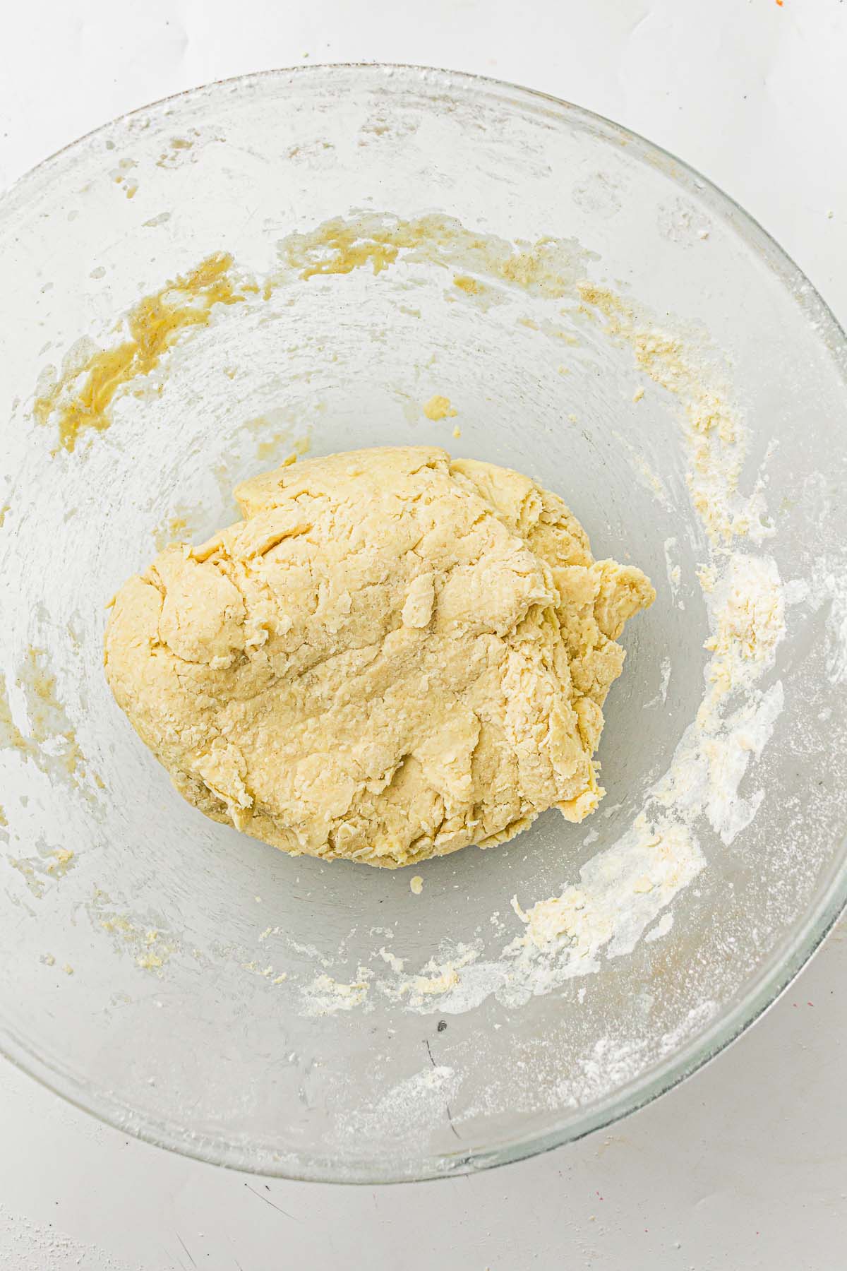 Soft dough formed in a glass mixing bowl.