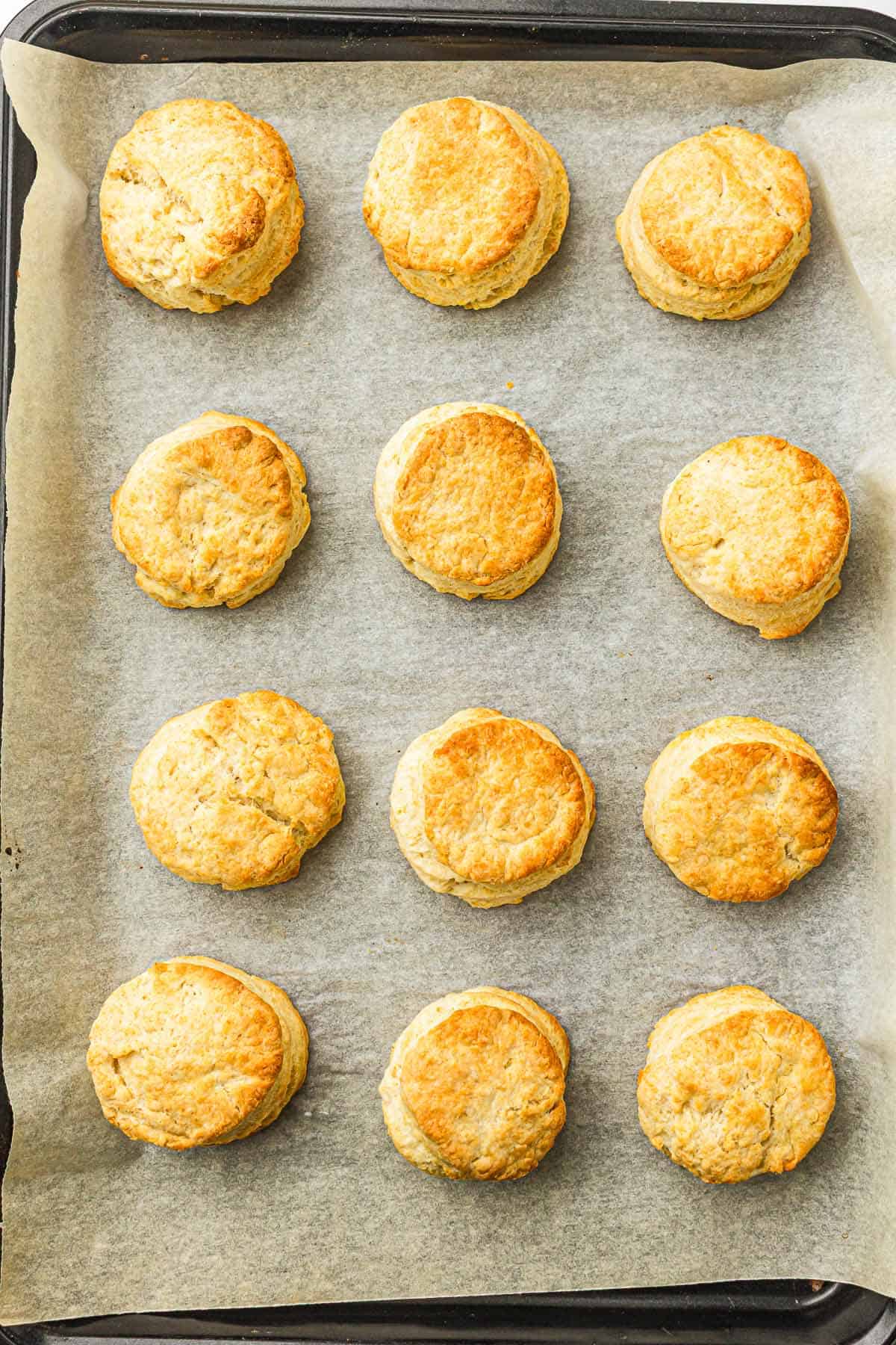 Golden biscuits baked on a parchment-lined baking tray.