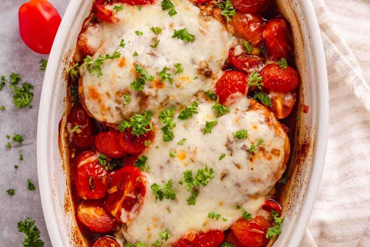 Baked chicken topped with melted cheese and roasted cherry tomatoes.