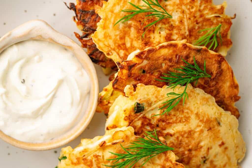 Crispy cabbage pancakes served with sour cream on a plate