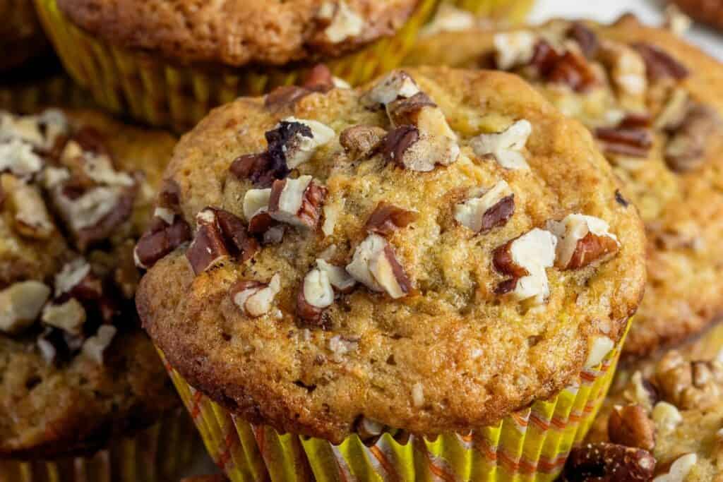 Banana muffins topped with chopped nuts in liners