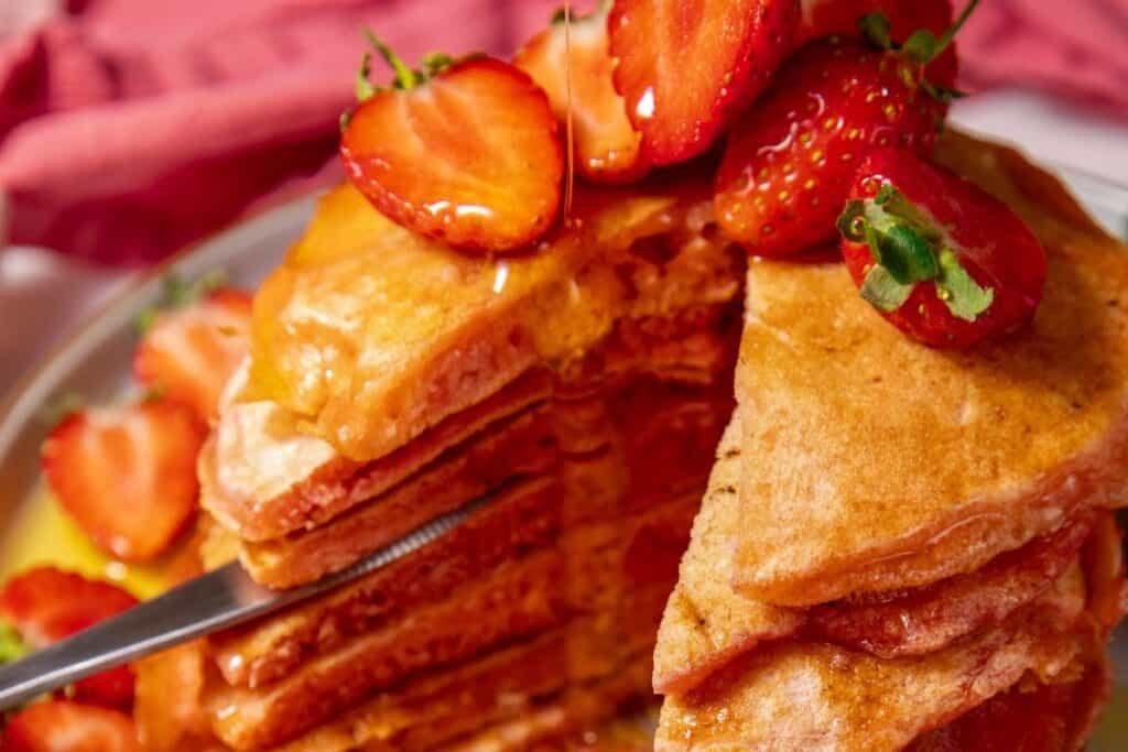 Stack of pancakes with strawberries and syrup