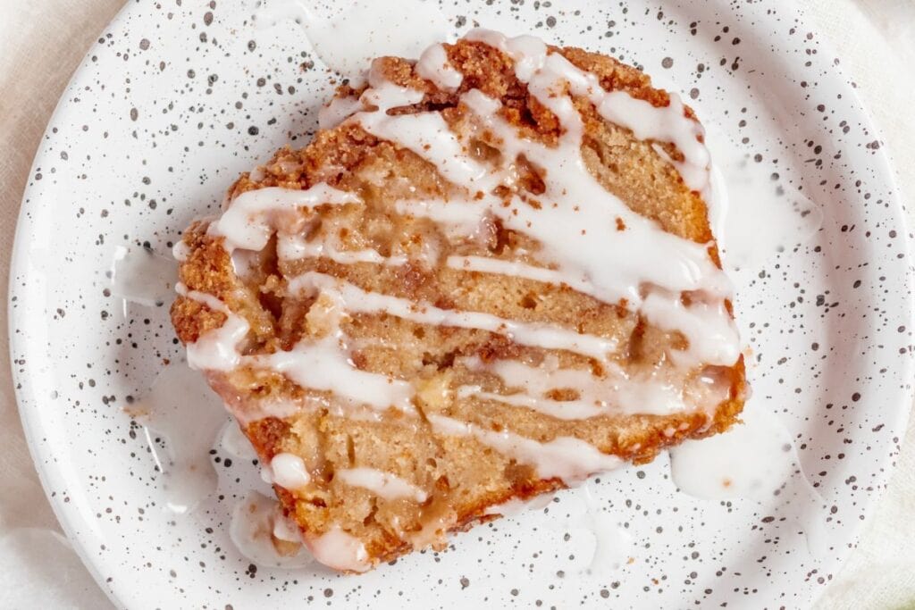 Slice of coffee cake with crumb topping and icing