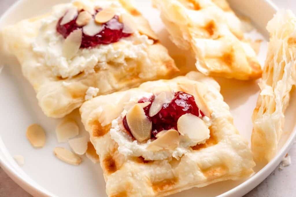 Waffles topped with fruit and powdered sugar