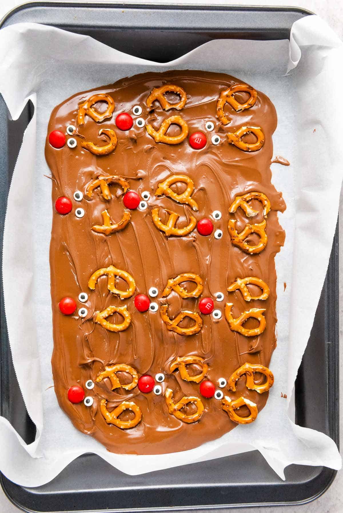Chocolate spread topped with pretzels, red candies, and candy eyes.