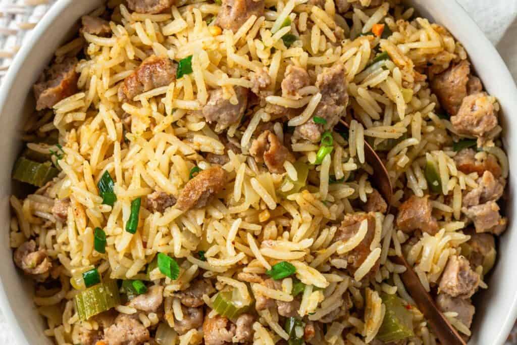 Pork dirty rice with herbs served in a white bowl