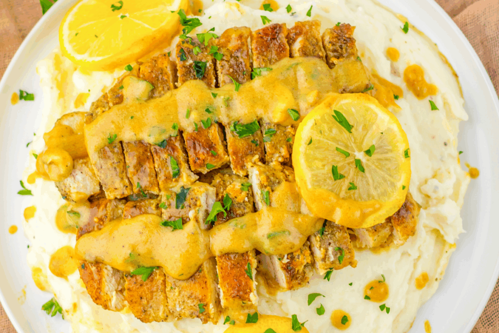 Lemon chicken with sliced lemons served on a white platter