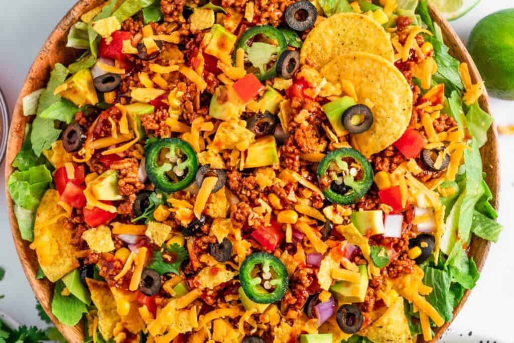 Colorful taco salad with ground beef, veggies, and tortilla chips