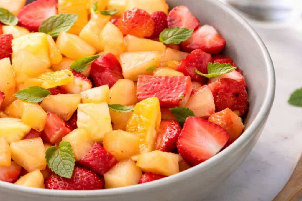 Bowl of mixed fresh fruit with strawberries, pineapple, and kiwi