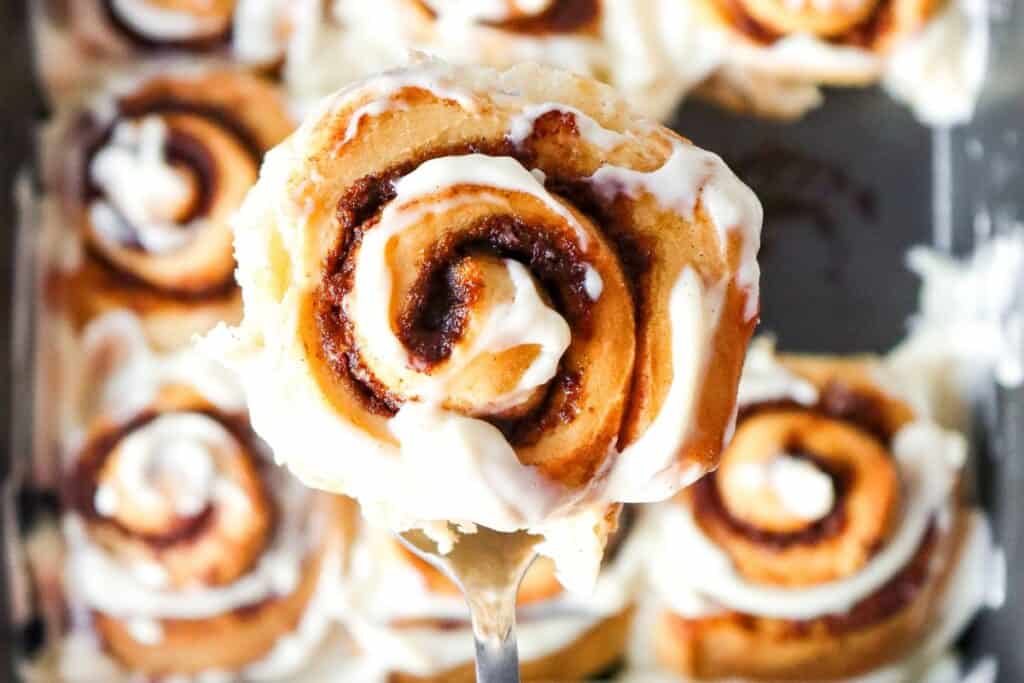 Homemade cinnamon rolls with icing on a tray