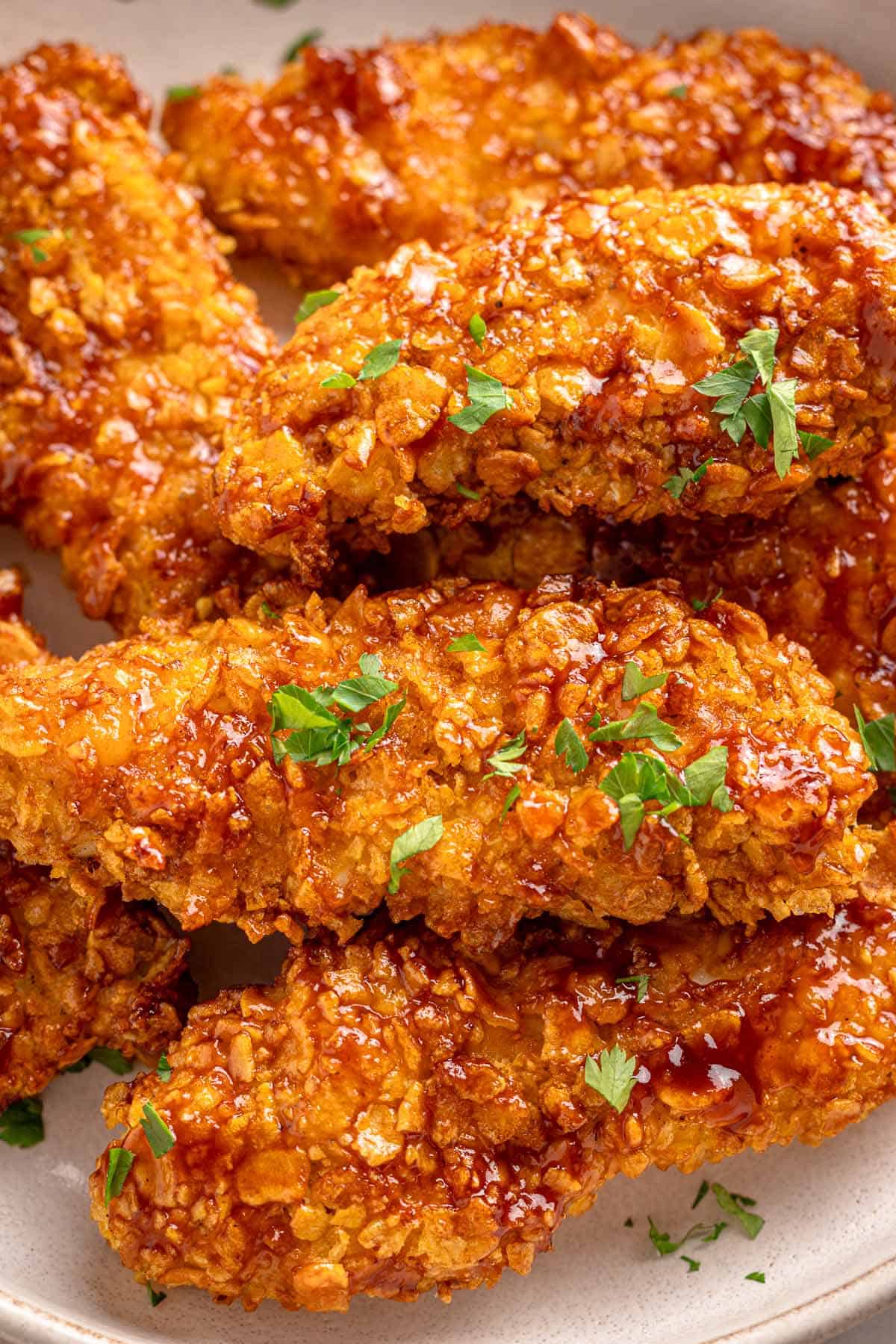 Barbecue-glazed cornflake chicken tenders topped with chopped parsley