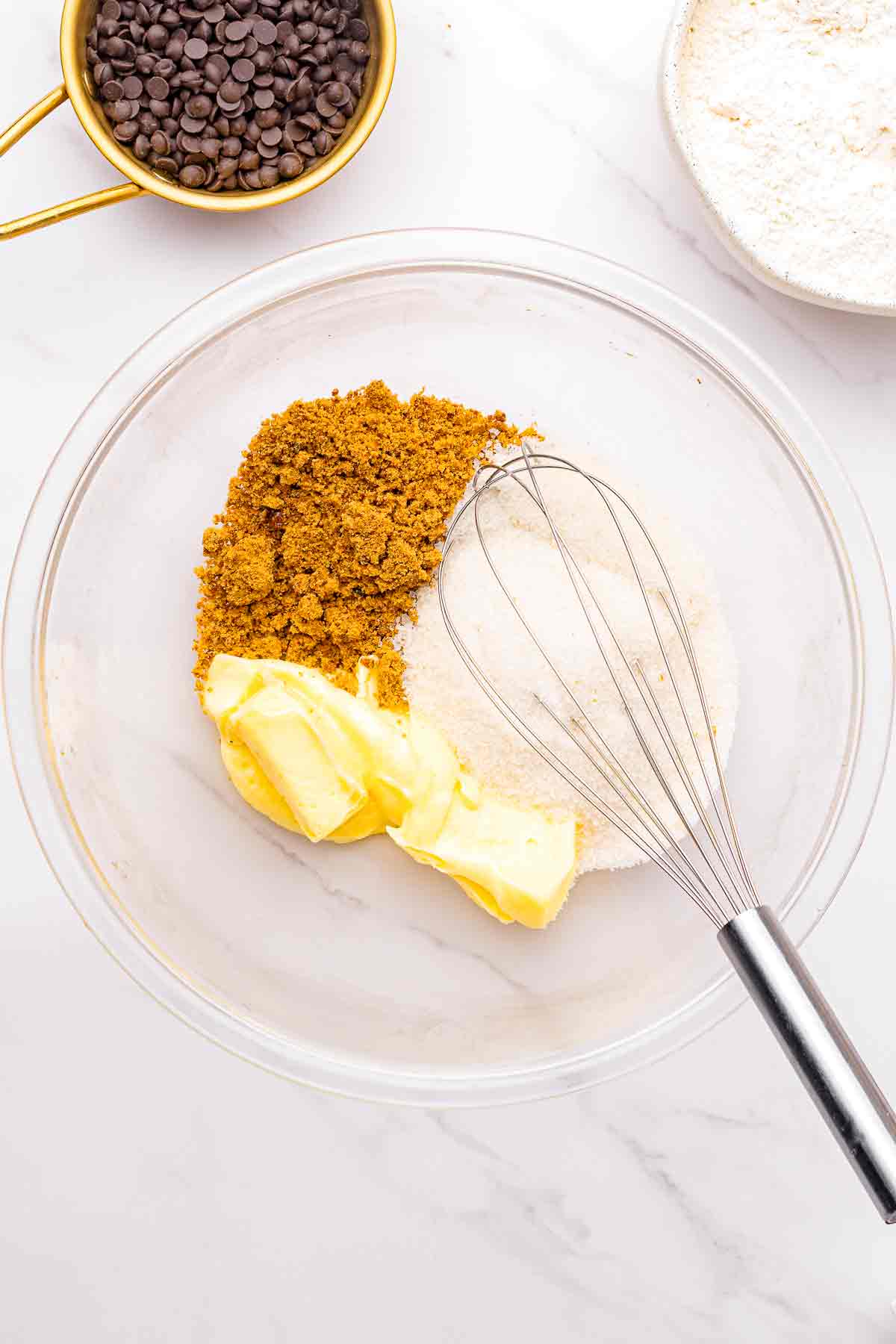 Butter and brown sugar in a glass bowl with a whisk