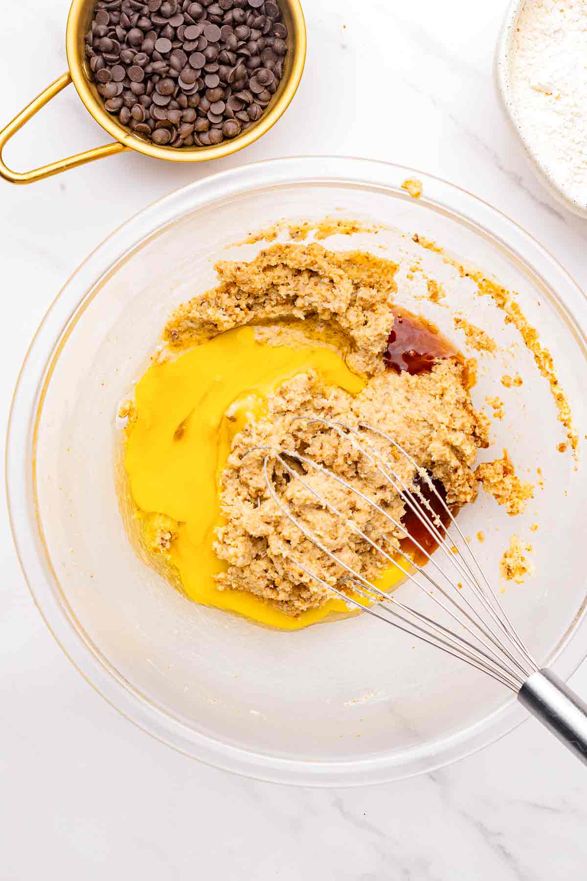 Cookie dough mixture with egg and vanilla being whisked together