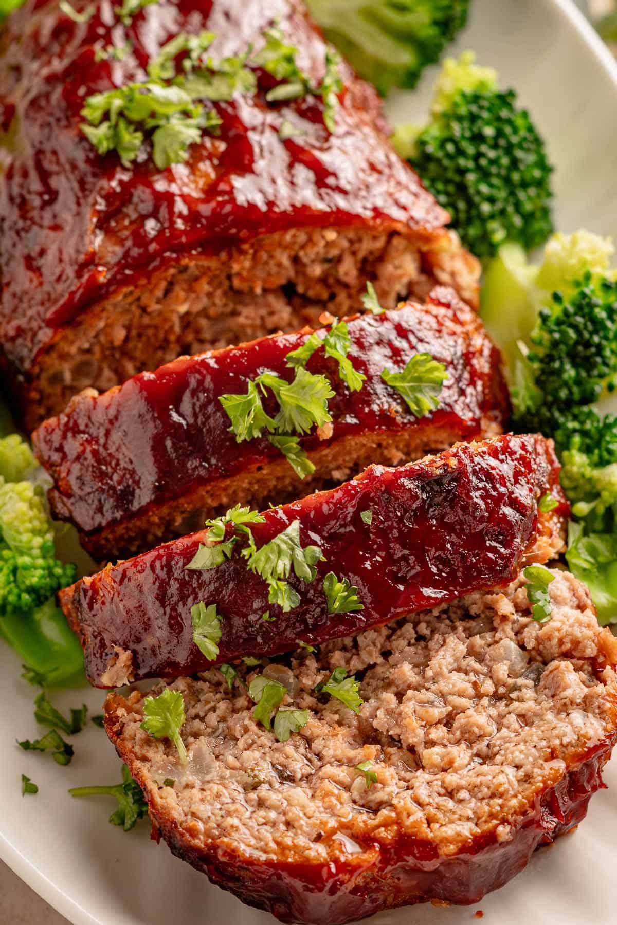 Sliced glazed meatloaf with broccoli and parsley