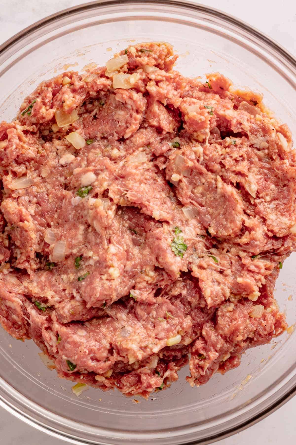 Mixed ground beef meatloaf mixture in a glass bowl