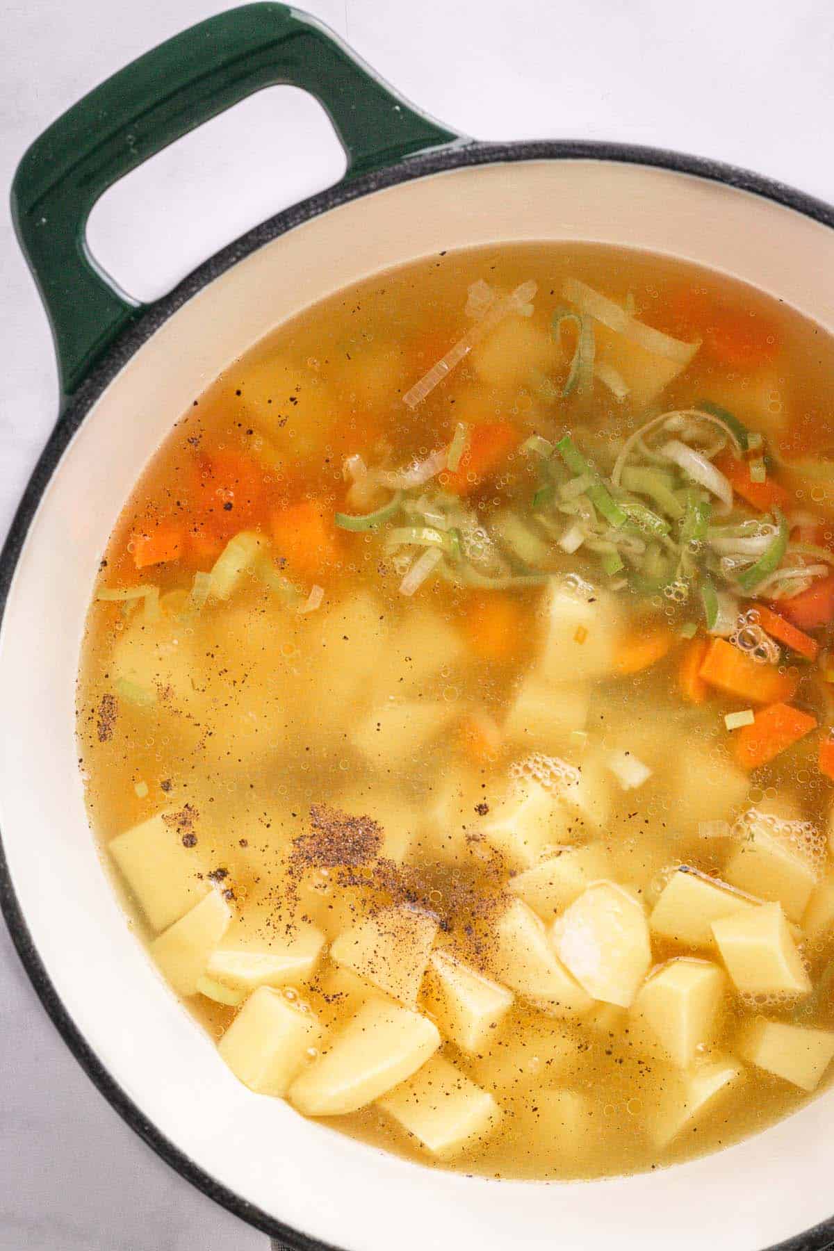 Broth added to potatoes and vegetables before simmering the soup.