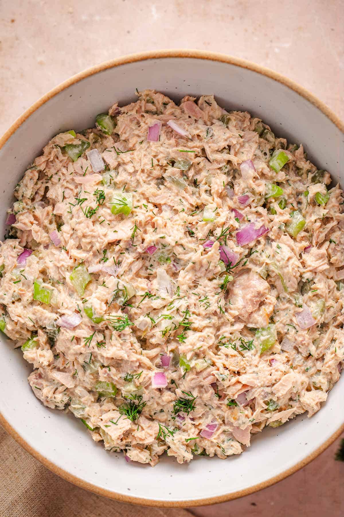 Bowl of creamy tuna salad with celery, red onion, and fresh dill