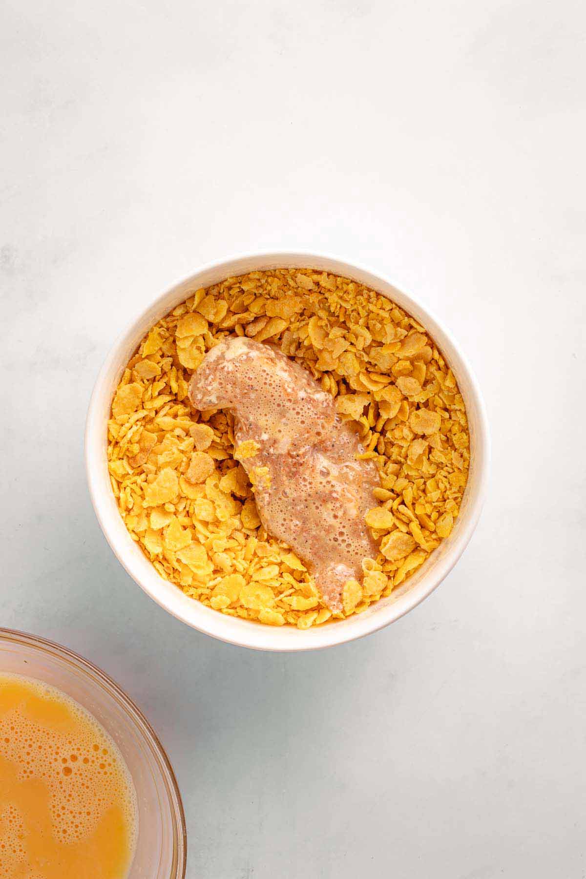 Chicken tender coated with crushed cornflakes before air frying