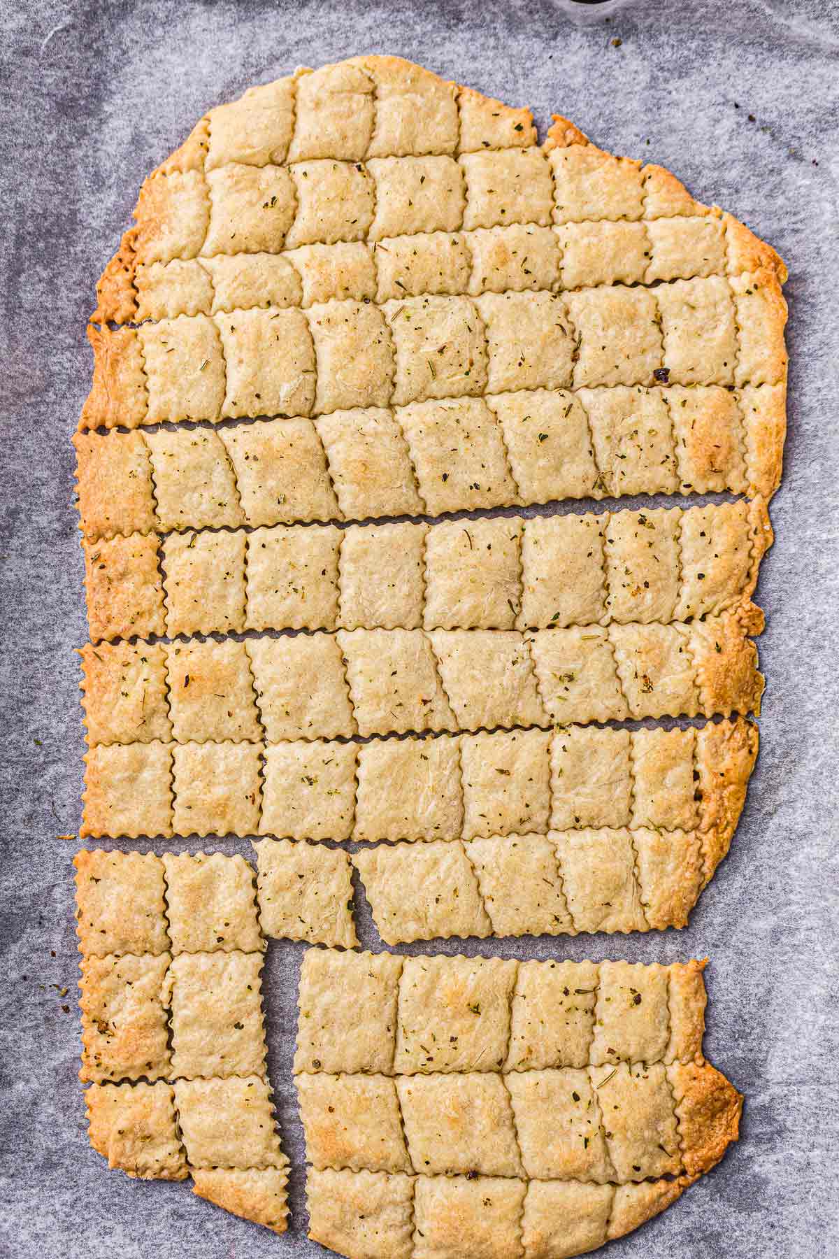 Homemade sourdough crackers cooling on a baking sheet