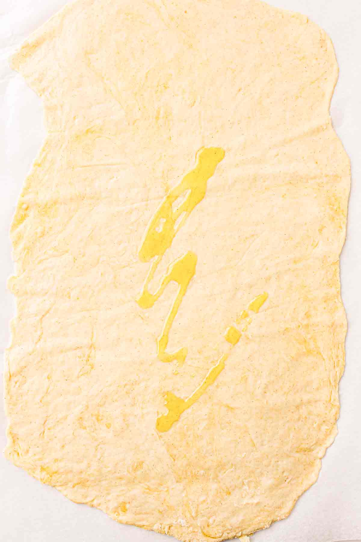 Olive oil drizzled over rolled cracker dough