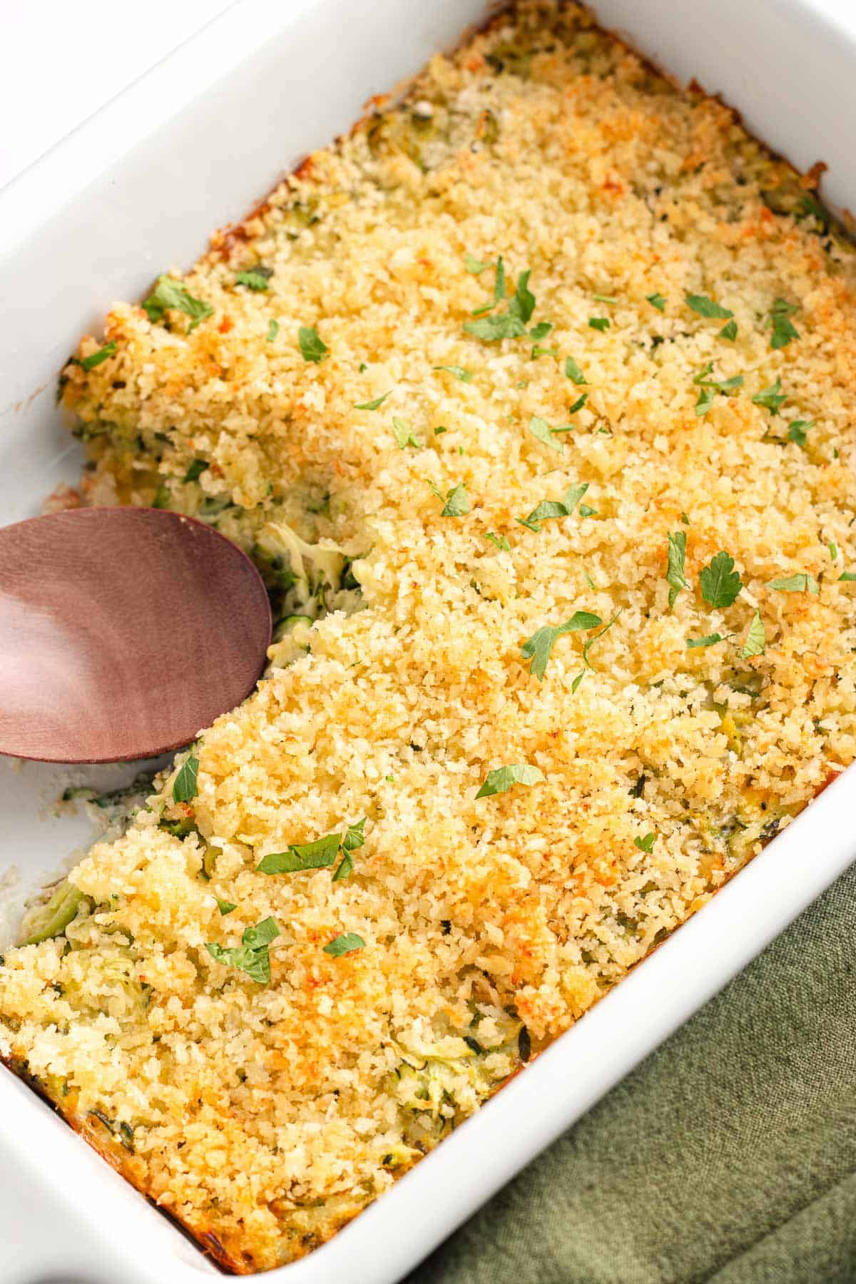 Slice of cheesy zucchini casserole with a crispy topping served on a plate