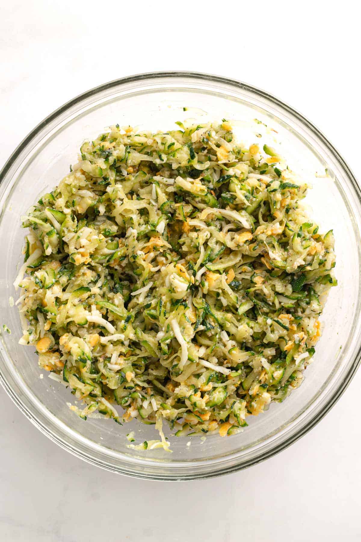 Mixed zucchini casserole filling combined in a glass mixing bowl