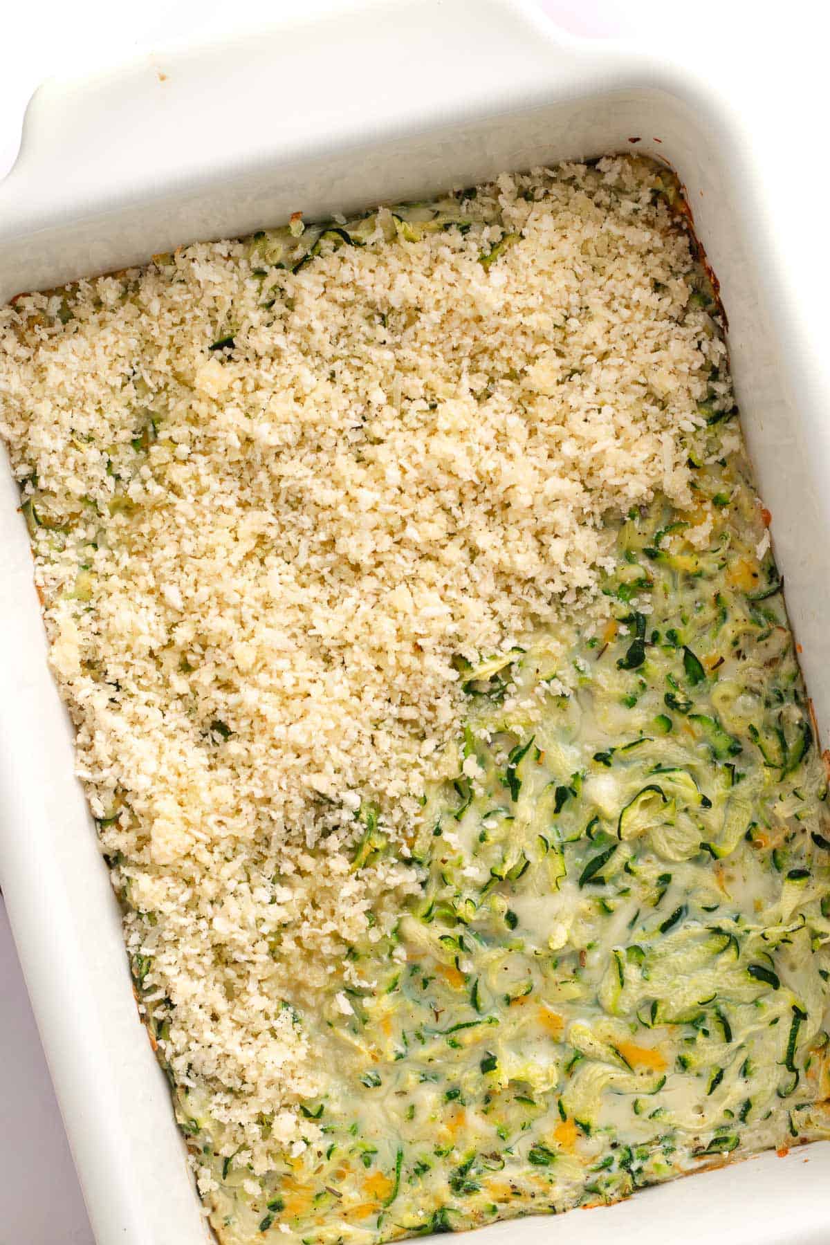 Breadcrumb topping sprinkled over the partially baked zucchini casserole