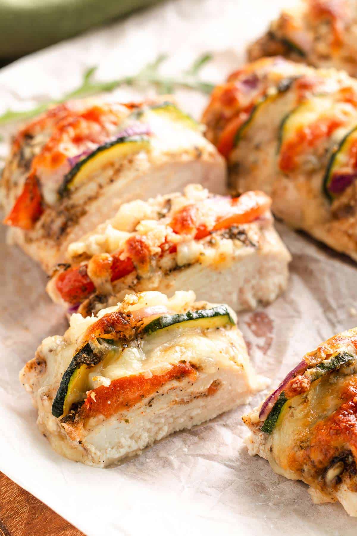 Sliced Mediterranean hasselback chicken with melted cheese and vegetables