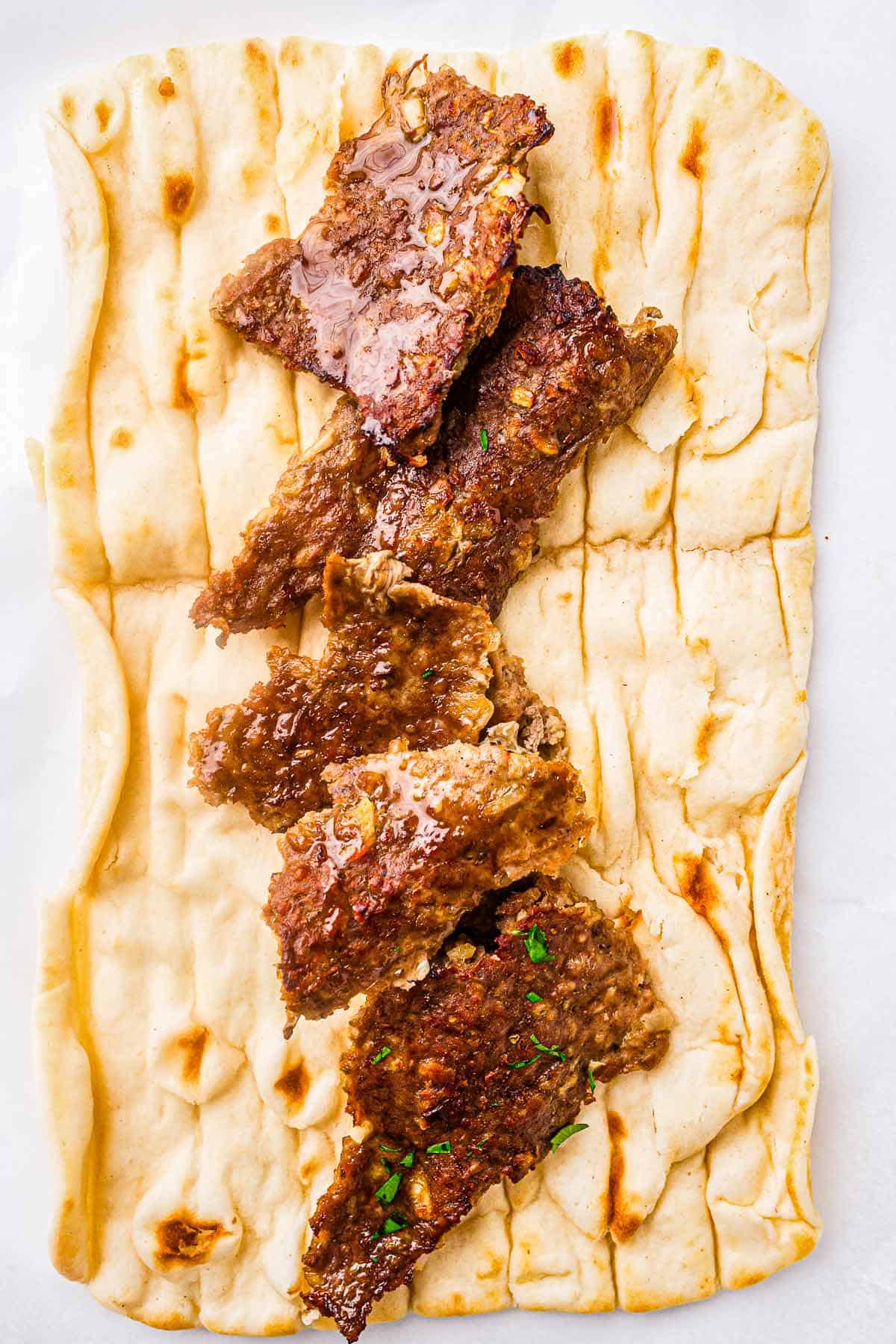 Flatbread topped with homemade kebab meat before adding vegetables