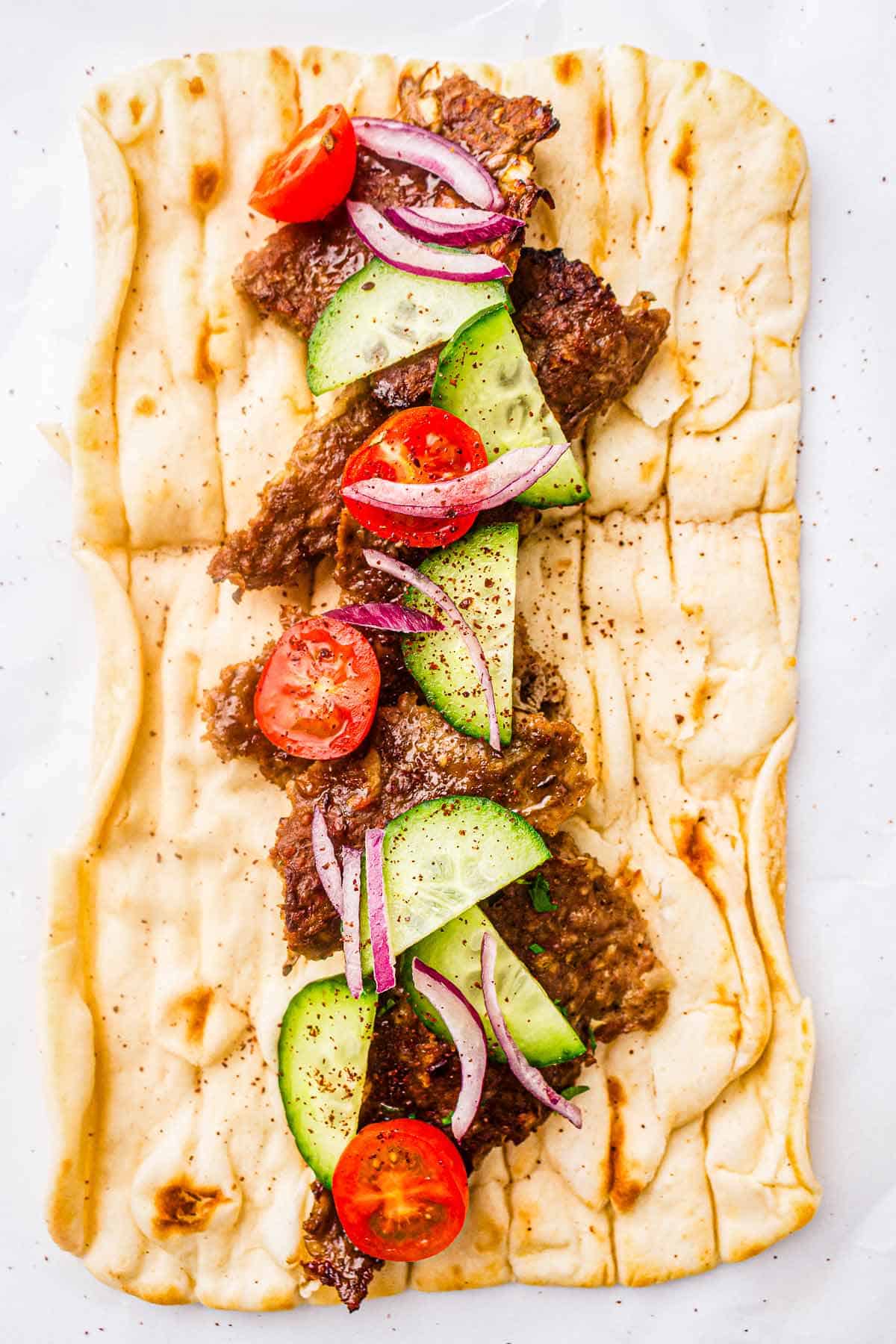 Homemade kebab wrap with meat, cucumber, tomatoes, and red onion