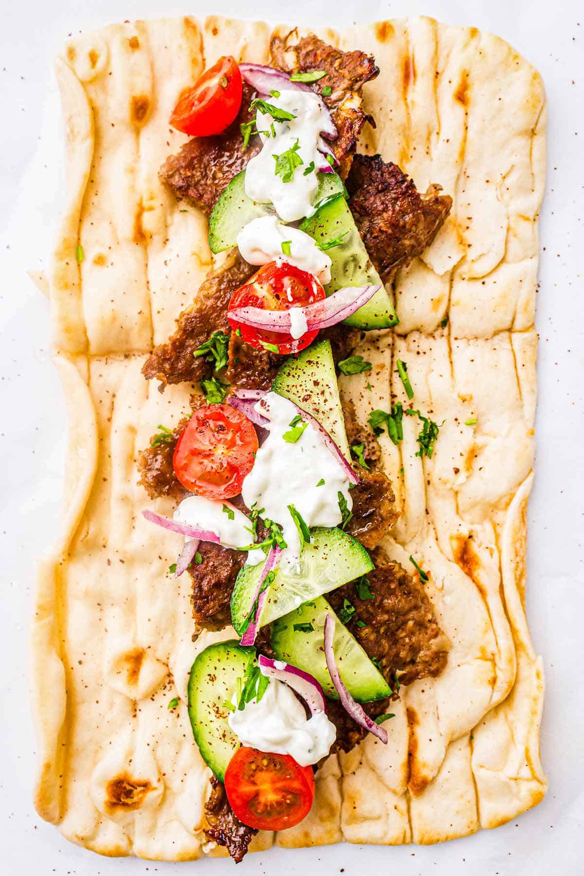 Homemade kebab wrap topped with garlic sauce and fresh parsley