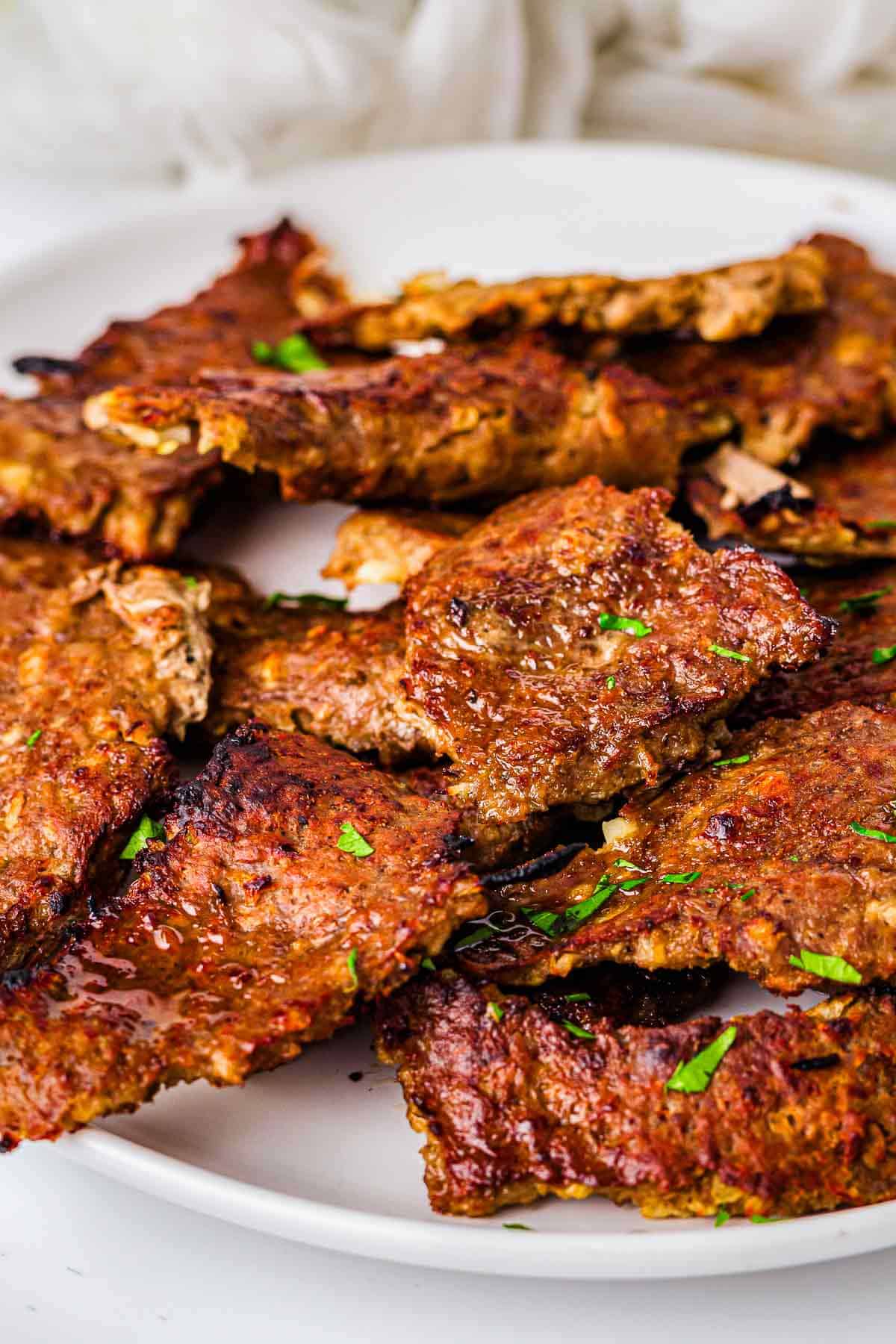 Plate of crispy homemade doner kebab meat garnished with chopped parsley