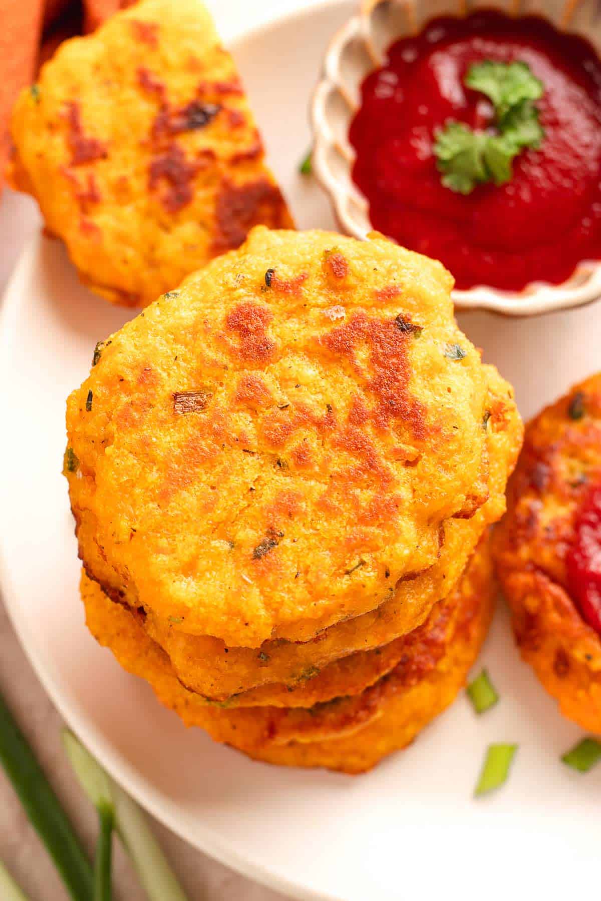 Stack of crispy red lentil veggie cakes with ketchup dipping sauce