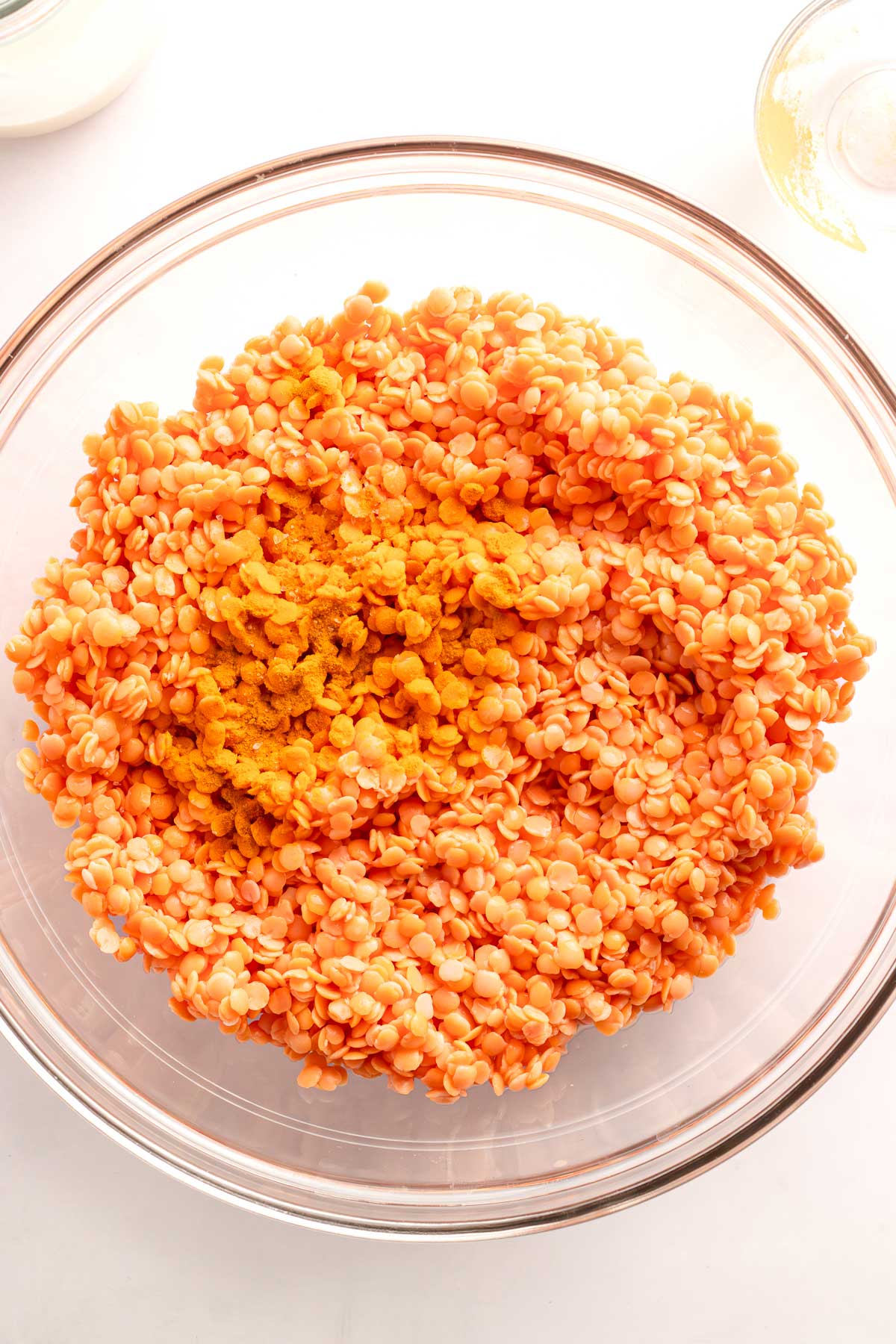 Soaked red lentils with turmeric in a glass bowl