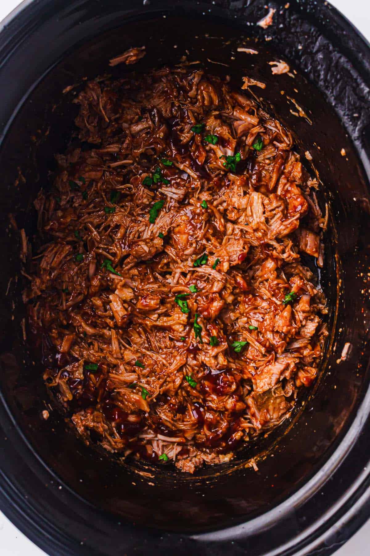 Slow cooker filled with tender shredded BBQ pulled pork
