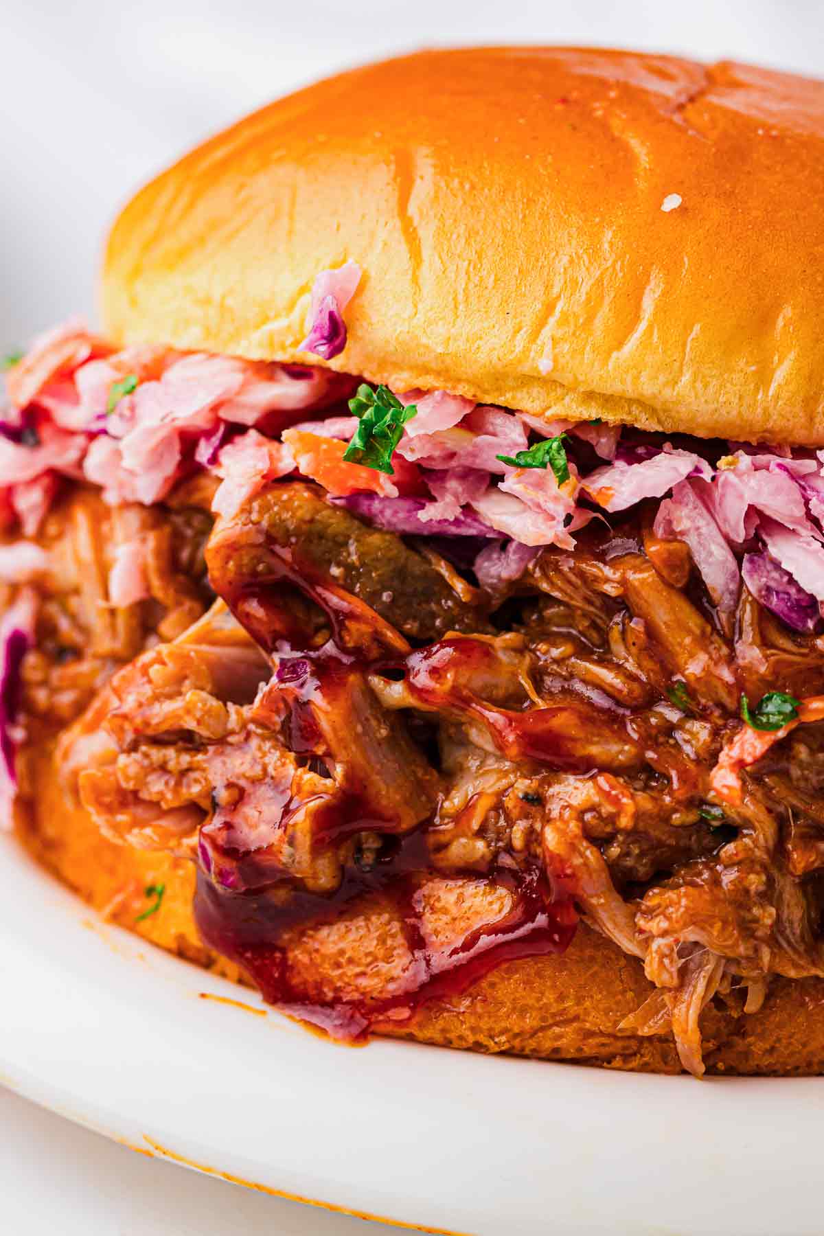 BBQ pulled pork sandwich topped with coleslaw on a toasted bun