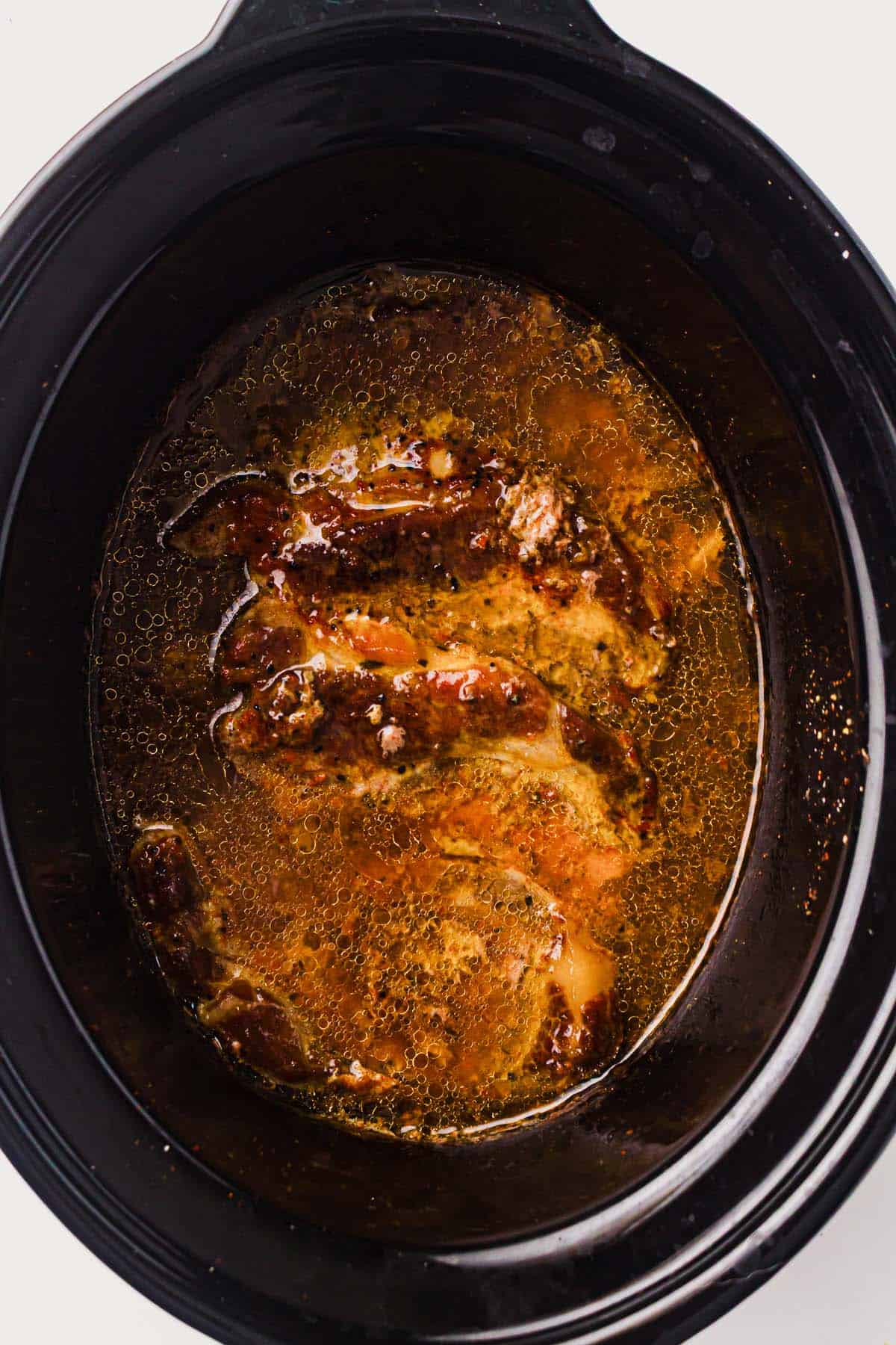 Cooked pork shoulder tested for tenderness with two forks