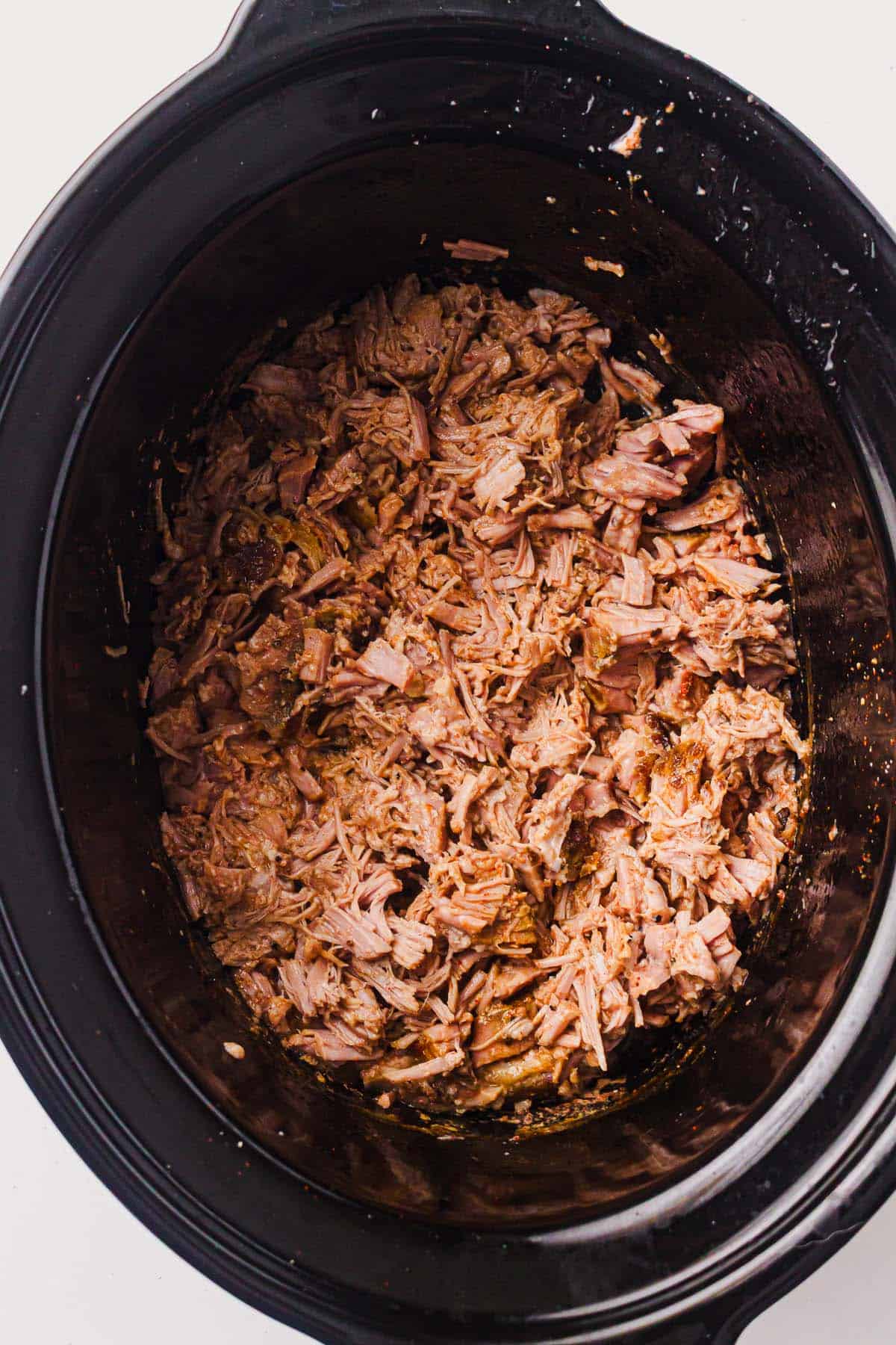 Shredded pulled pork in a slow cooker before adding BBQ sauce